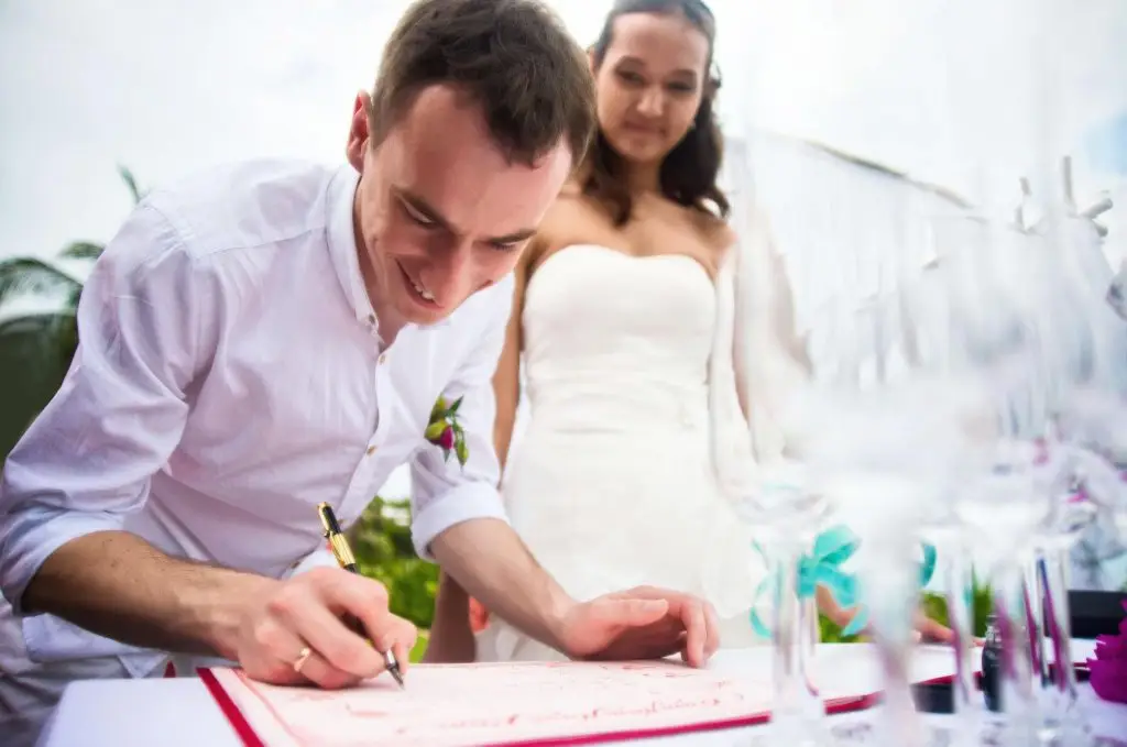 Couple signing their marriage certificate