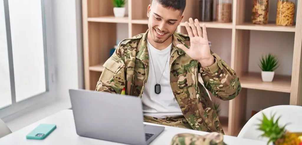 Military man waves to his partner over video call