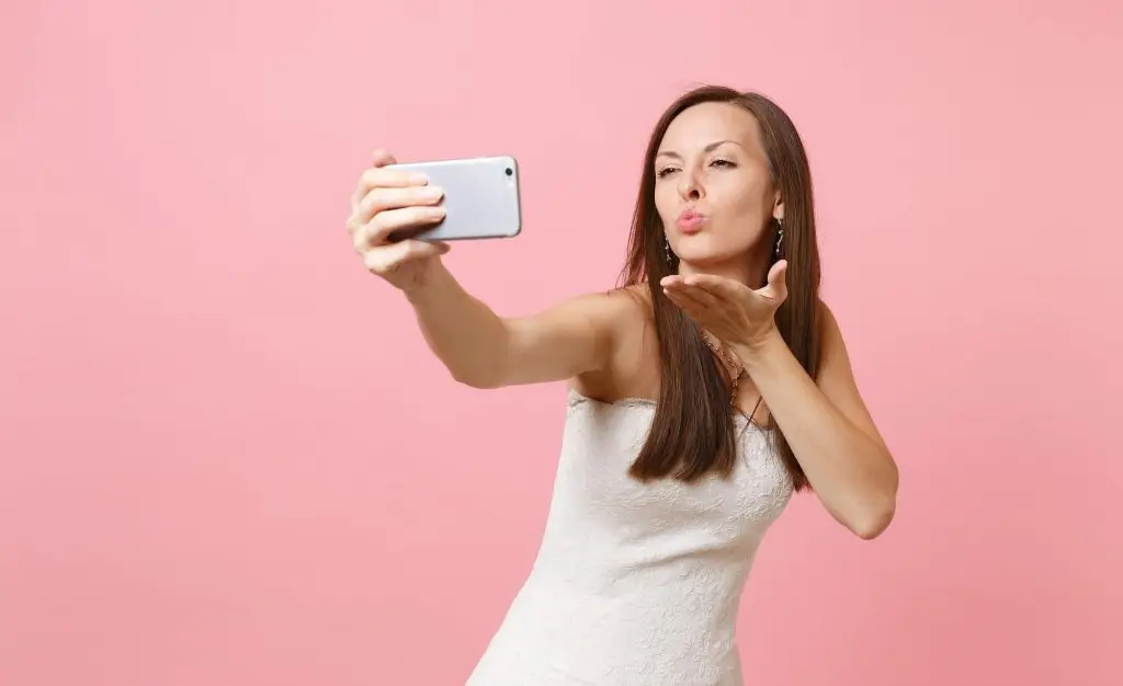 Wife sending kisses to husband through the phone after getting married online.