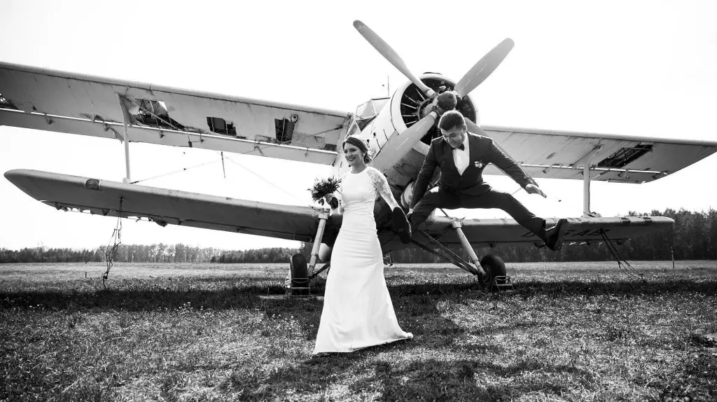 Military couple getting married in front of an airplane